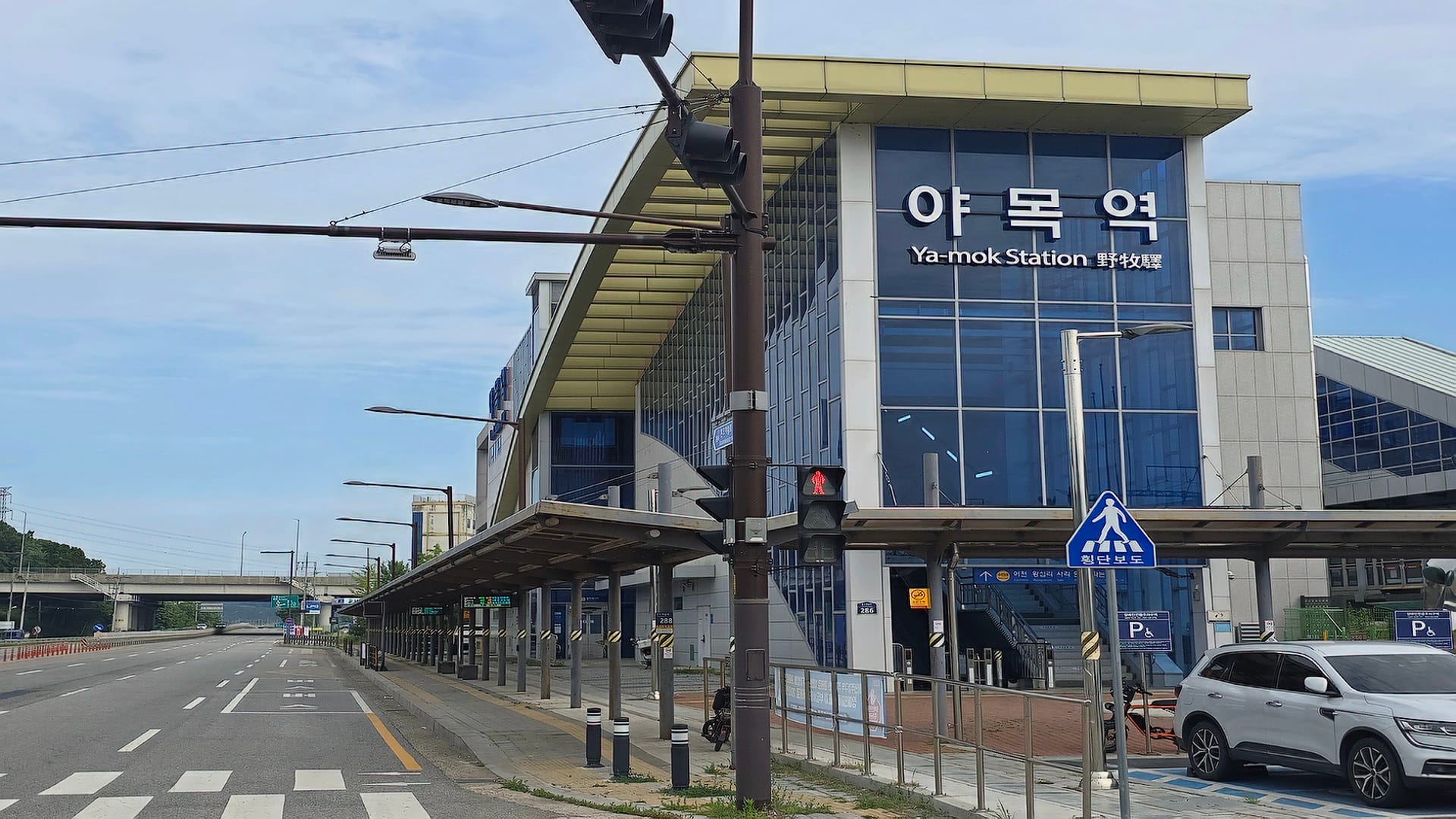 수인분당선 야목역 한글 및 영문 간판이 부착된 지하철 역사 전면 유리 외관과 주변 한적한 도로 전경