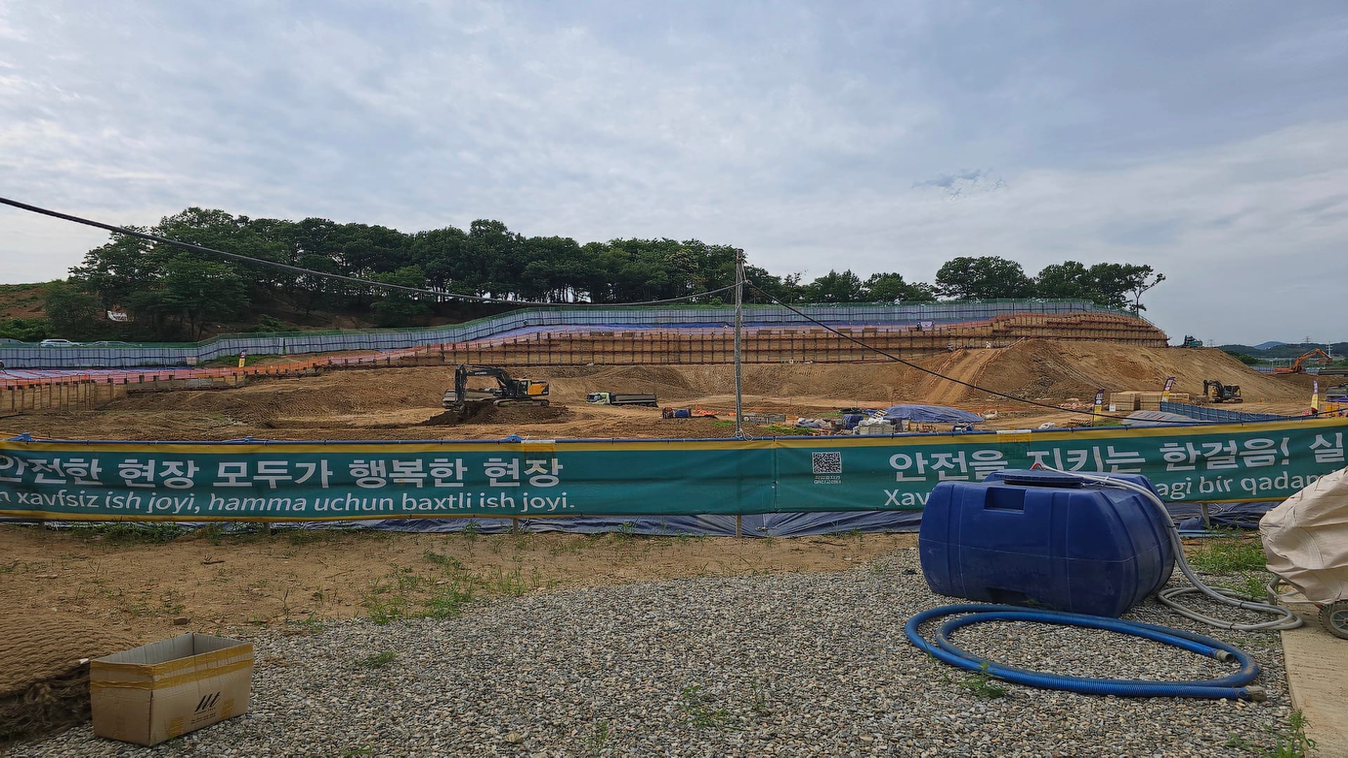 화성 비봉 서희스타힐스 가설 방음벽 너머로 포크레인과 덤프트럭이 가동되며 대규모 대지 평탄화 및 옹벽 주입 공사가 진행 중인 내부 전경