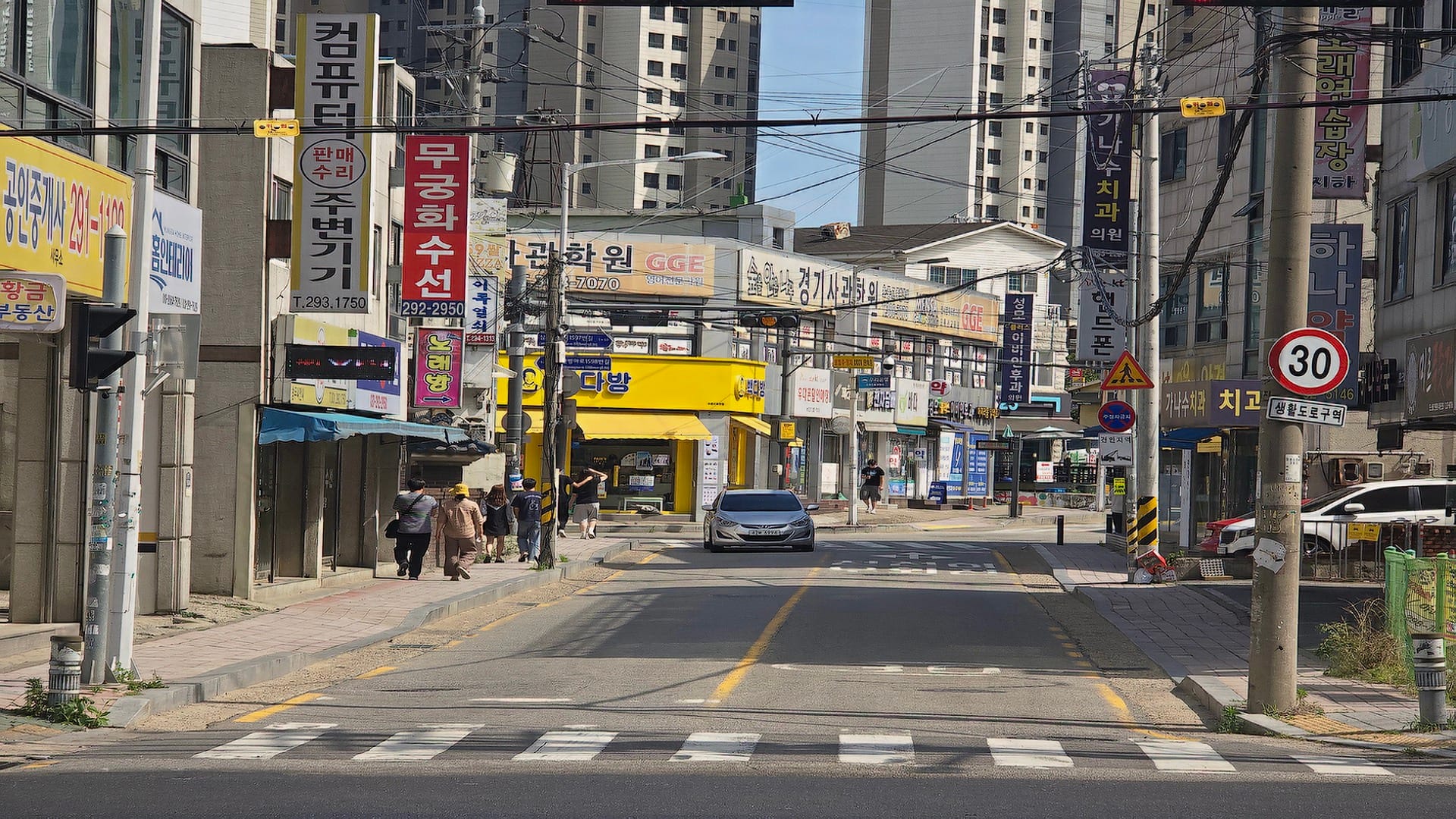 오목천역 더리브 단지 정문에서 지하철역으로 향하는 이면 도로 보도블록과 횡단보도 보행로 정경